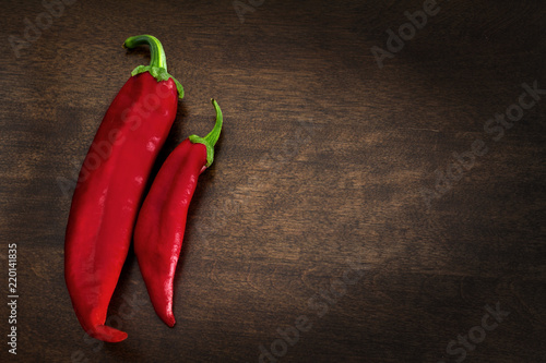 Two Red Chile Peppers on Brown Background