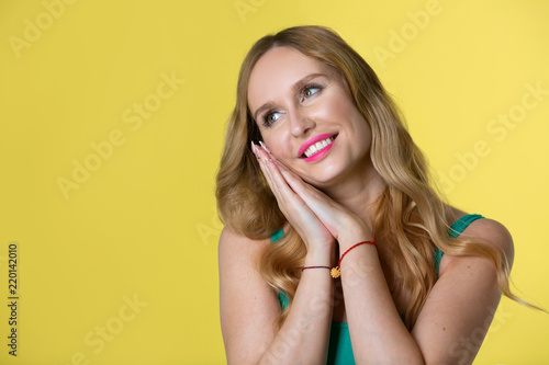 beautiful young girl with her hair on yellow background