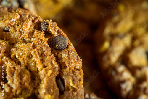 Chocolate chip cookies on rustic dark black background. Stacked chocolate chip cookies on brown napkin. Symbolic image with place for text. Freshly baked. Concept for a tasty snack. Sweet dessert