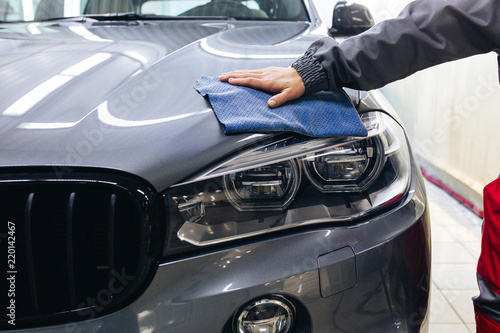 Car detailing: the man holds the microfiber in hand.