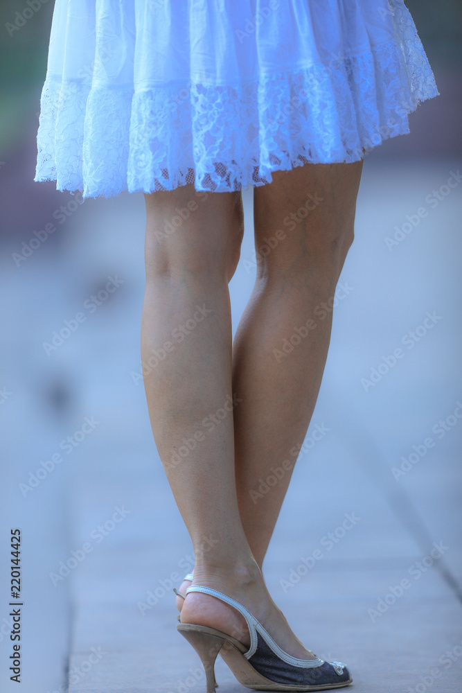 beautiful female legs in white dress and high heels beautiful female legs in white dress and high heels