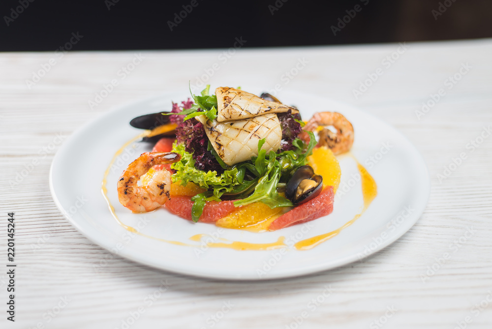 salad of seafood and citrus, on a white plate salad of seafood and citrus, on a white plate