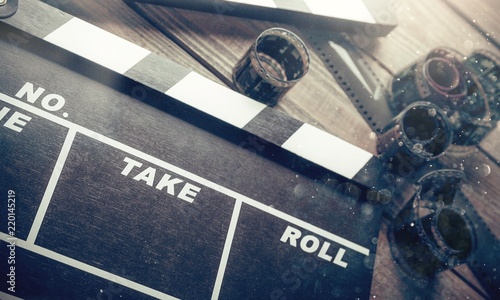 Fotografia Movie clapper board and film tapes on wooden background