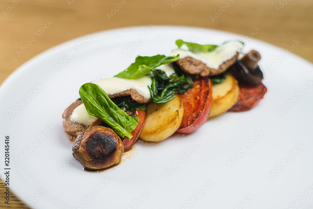 vegetables and mushrooms grilled with basil, on a white plate