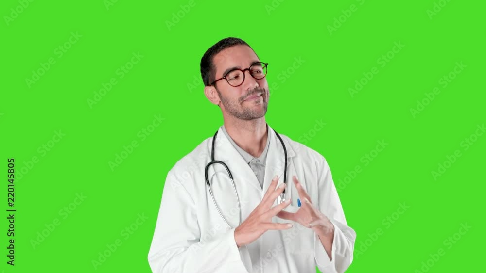 Confident young doctor doing a gesture of concentration against green background Confident young doctor doing a gesture of concentration against green background