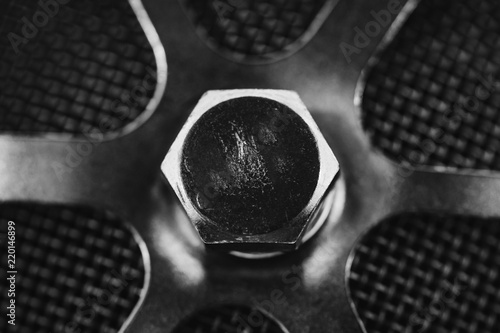 Round metal part with bolt close-up in grayscale. Monochrome background from auto part with copy space.