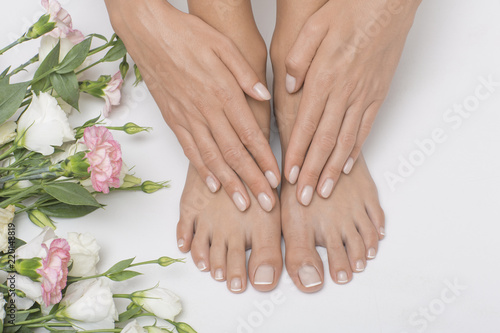 Fototapeta Naklejka Na Ścianę i Meble -  The picture of ideal done manicure and pedicure. Female hands and legs in the spa spot.