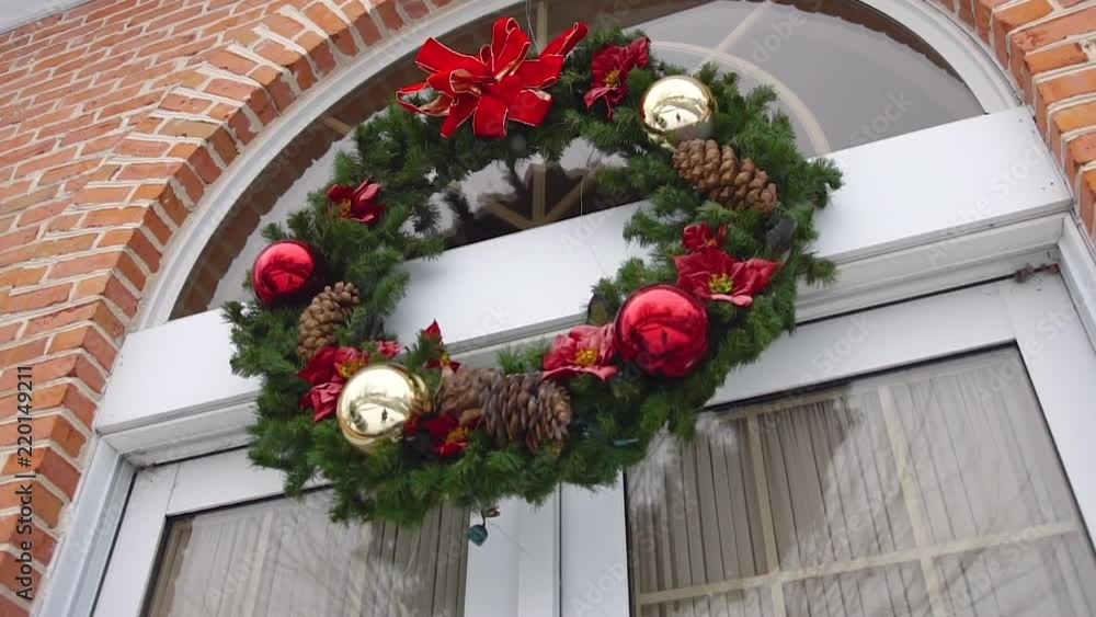Snow falling on an outdoor Christmas wreath in slow motion Snow falling on an outdoor Christmas wreath in slow motion