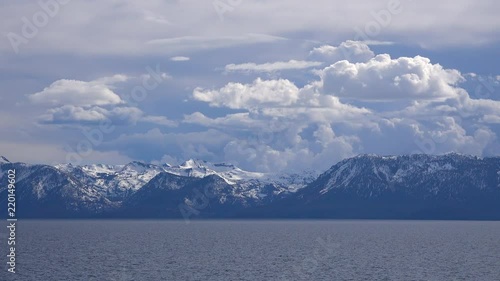 Beautiful time lapse of thunderstorm cloud formations rising behind snow covered Mt. Tallac and the Desolation Wilderness near Lake Tahoe, California. photo