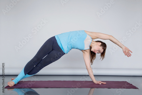Young woman practicing Side Plank Pose (Vasisthasana)