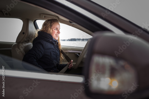 Woman driving a car - female driver at a wheel of a modern car (shallow DOF; color toned image)