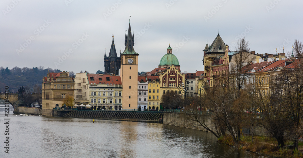 View of the left bank of the Vltava River in Prague, Old place, Old Town water tower. The tower with an elongated pointed spire and narrow Gothic turrets. Near the Old Town Bridge Tower. 