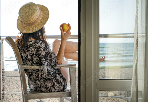 A girl with an apple looking to the sea