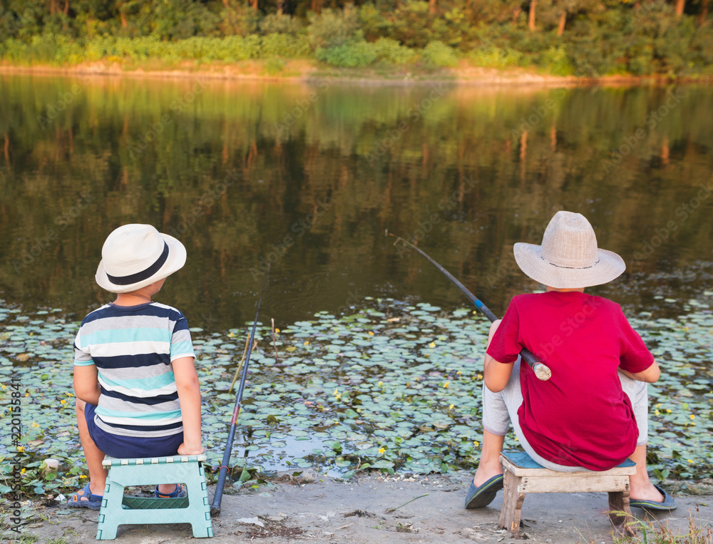 Two little boys fishing on the lake. Stock Photo