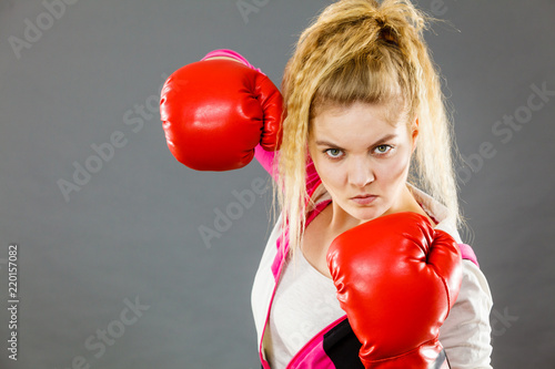Angry woman wearing boxing gloves © Voyagerix