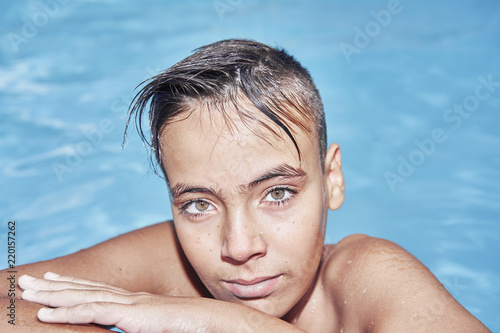 Boy with green eyes in the swimming pool