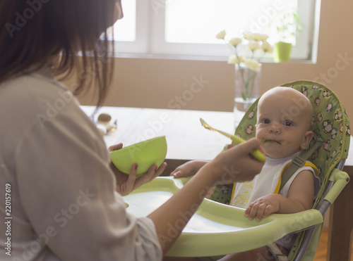 The mother feeds the baby with porridge photo