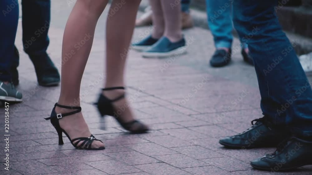 Legs of two professional dancers doing a Latino dance and having fun at a dance party event in the street slow motion. Legs of two professional dancers doing a Latino dance and having fun at a dance party event in the street slow motion.