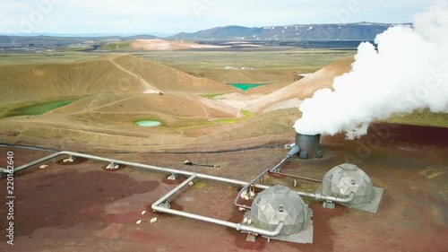 Beautiful drone shot of the Krafla geothermal area in Iceland with pipes, steaming vents and sheep warming themselves.