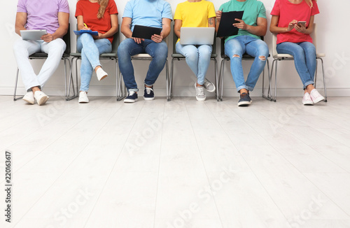 Group of young people waiting for job interview on chairs