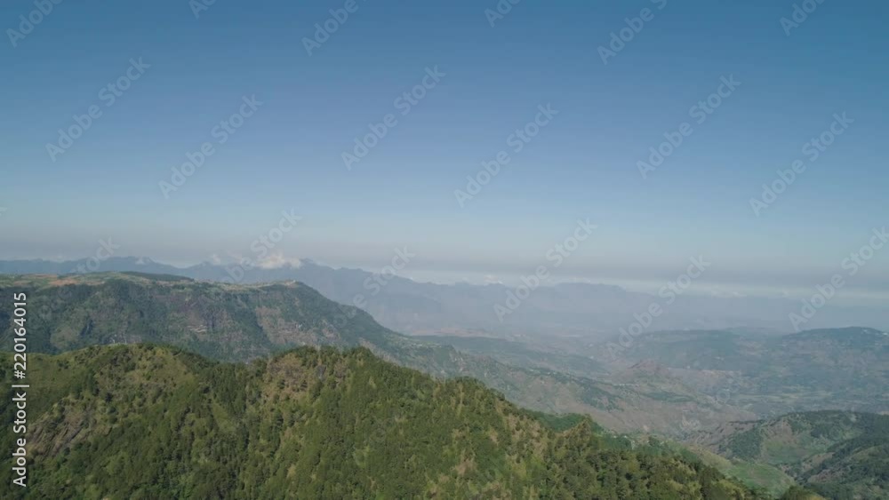 Aerial view of mountains covered forest, trees in clouds. Cordillera region. Luzon, Philippines. Slopes of mountains with evergreen vegetation. Mountainous tropical landscape. Aerial view of mountains covered forest, trees in clouds. Cordillera region. Luzon, Philippines. Slopes of mountains with evergreen vegetation. Mountainous tropical landscape.