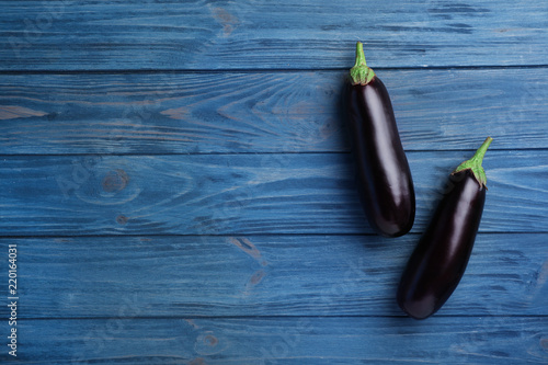 Raw ripe eggplants on wooden background, top view