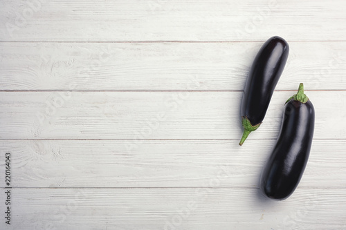 Raw ripe eggplants on wooden background, top view