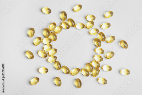 Frame of cod liver oil pills with space for text on white background, top view