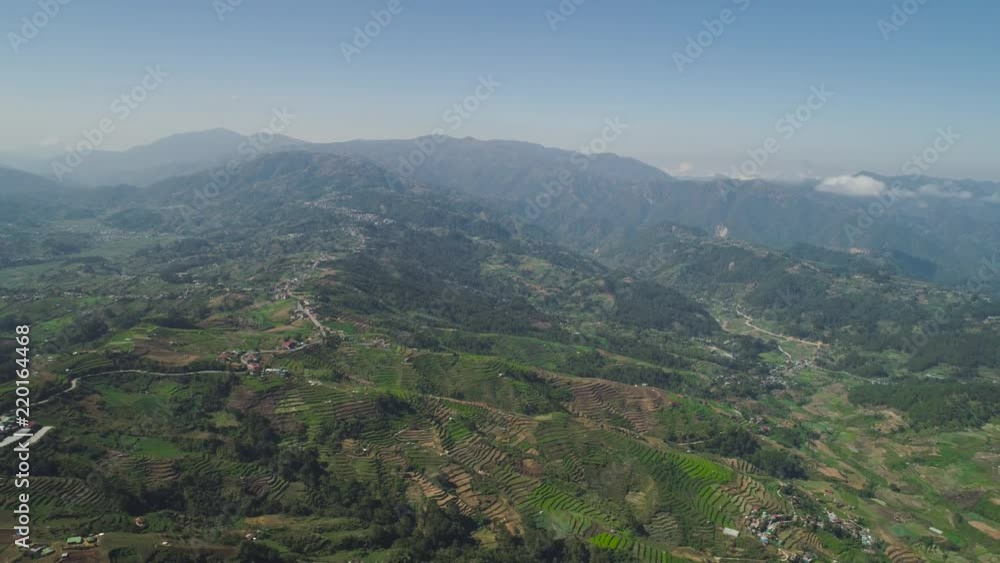 Aerial view of rice terraces and agricultural farm land on the slopes of mountains valley. Cultivation of agricultural products in mountain province. Mountains covered forest, trees. Cordillera region Aerial view of rice terraces and agricultural farm land on the slopes of mountains valley. Cultivation of agricultural products in mountain province. Mountains covered forest, trees. Cordillera region