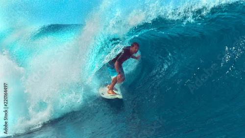 Obraz ZBLIŻENIE: Młody profesjonalny surfer jeździ na Tahiti z zapierającą dech falą.