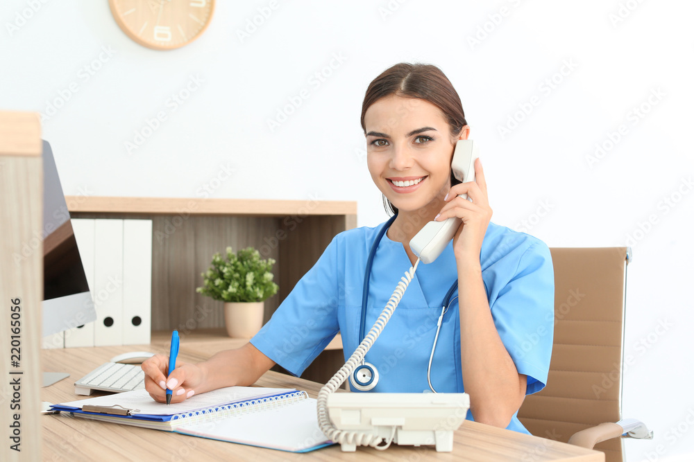 Female medical assistant at workplace in clinic. Health care service - obrazy, fototapety, plakaty 
