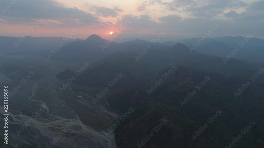 Aerial view sunset in mountain valley along which the river flows, surrounded by mountains covered with forest. Pinatubo, Cordillera region. Luzon, Philippines. Mountain landscape. Aerial view sunset in mountain valley along which the river flows, surrounded by mountains covered with forest. Pinatubo, Cordillera region. Luzon, Philippines. Mountain landscape.