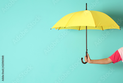 Woman holding beautiful umbrella on color background with space for design photo