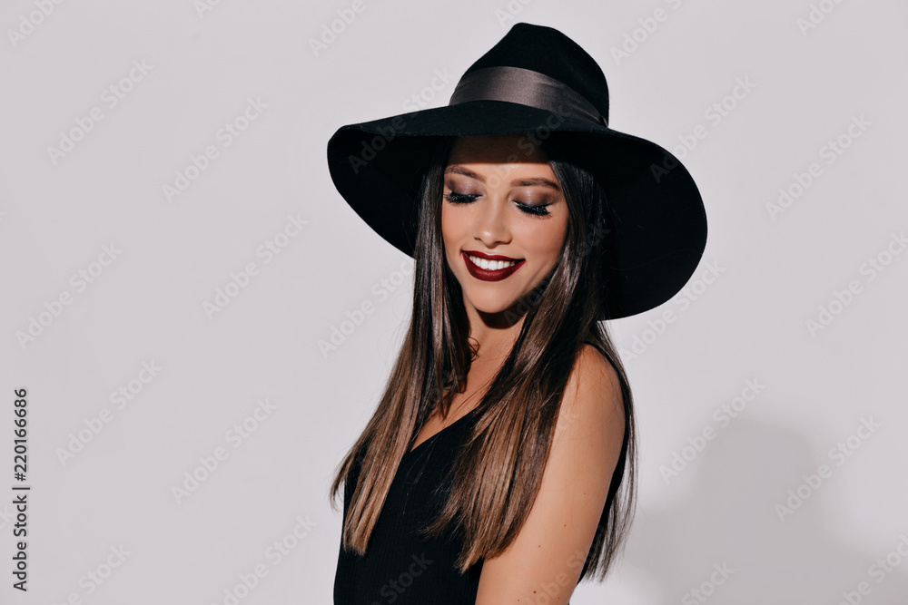 Halloween Witch posing on isolated background. Beautiful young effective woman in witches hat and costume holding pumpkin. Wide Halloween party art design Halloween Witch posing on isolated background. Beautiful young effective woman in witches hat and costume holding pumpkin. Wide Halloween party art design