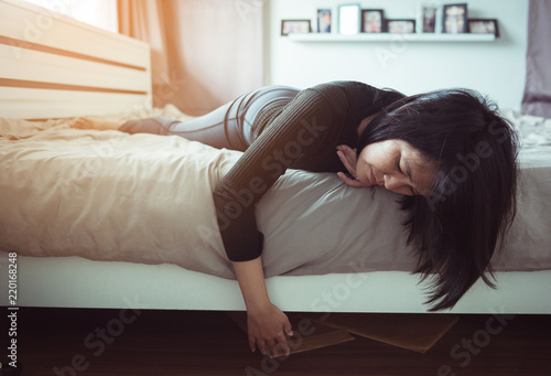 Asian woman bent and searching document under bed lost thing