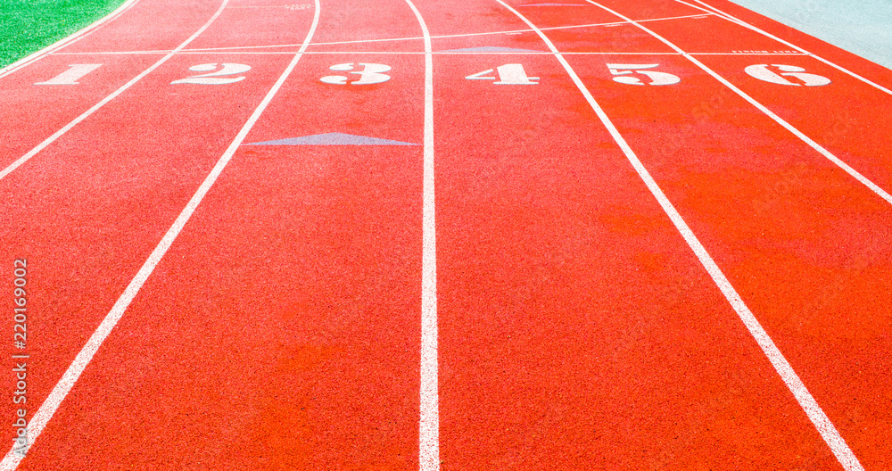 starting line on an empty stadium running track with 6 numbered lanes
