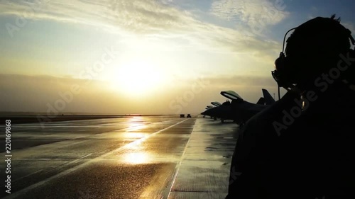Beautiful dolly shot around Air Force pilot at sunset with his fighter jet.
