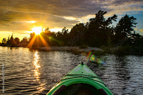 Kayak on a lake at a fiery sunset. Muskoka region Ontario photo
