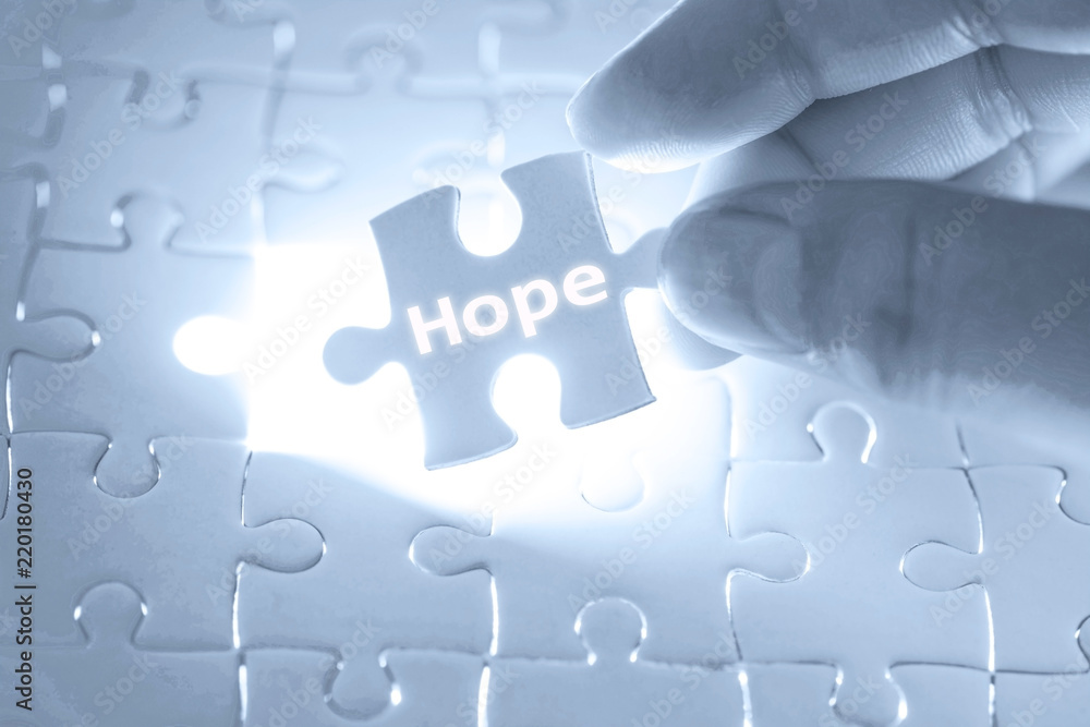 Businessman hand holding a jigsaw puzzle with hope word. Businessman hand holding a jigsaw puzzle with hope word.