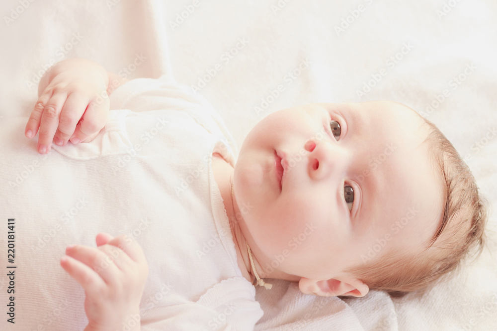 Smiling baby on the bed, soft focus background Smiling baby on the bed, soft focus background
