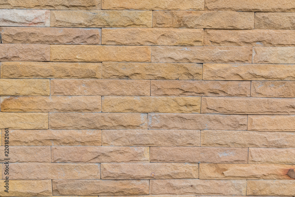 Fototapeta premium yellow stone wall made with stone blocks