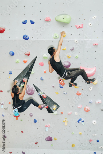 Man and woman climbing in bouldering gym