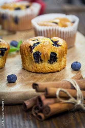 Muffins with blueberries, chocolate and cinnamon on a wooden board. Sweet dessert