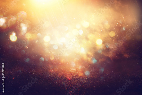 glitter vintage lights background. black  blue  purple and gold. de-focused.