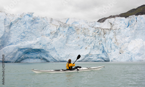 Woman kayaking in front of McBride glacier in Glacier Bay National Park, Alaska, USA