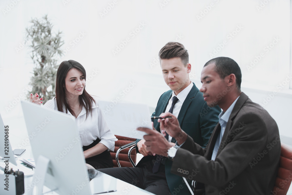 business team talking while sitting at a Desk business team talking while sitting at a Desk