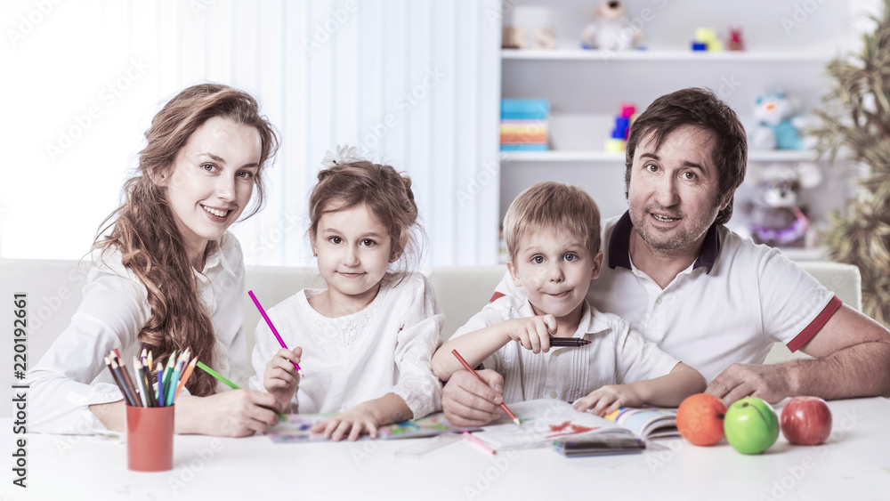 mom and dad are painting with the children sitting at the table in the nursery mom and dad are painting with the children sitting at the table in the nursery