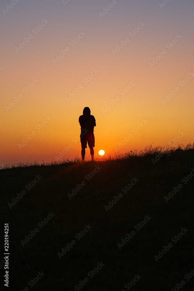 Man looking on rising sun