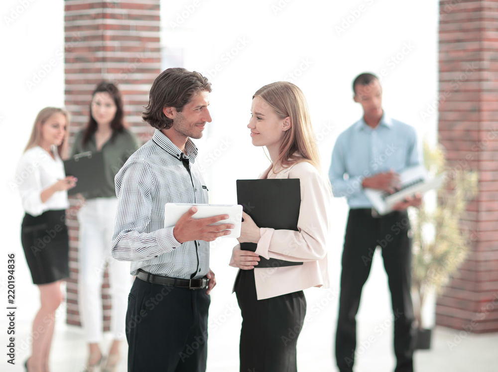 business colleagues talking, standing in a modern office business colleagues talking, standing in a modern office