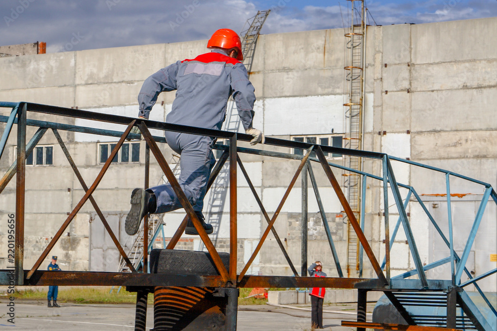 Competitions firefighters. The fireman overcomes the obstacle.